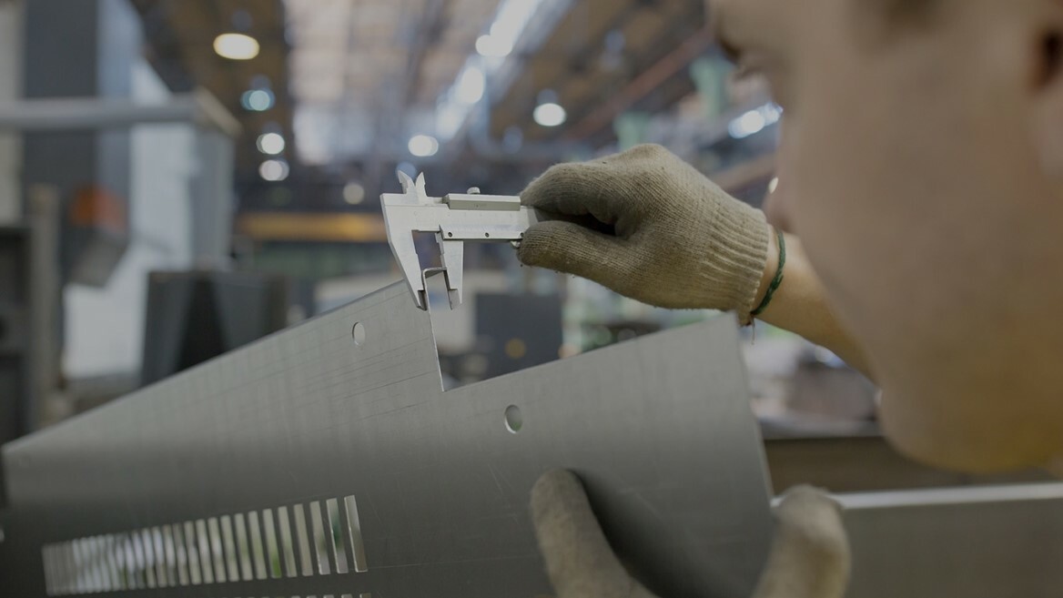 someone inspecting a metal part