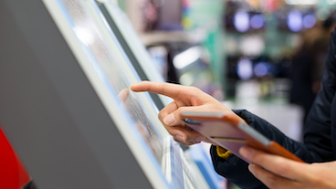 person interacting with a touch public kiosk